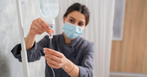A nurse adjusts an intravenous drip
