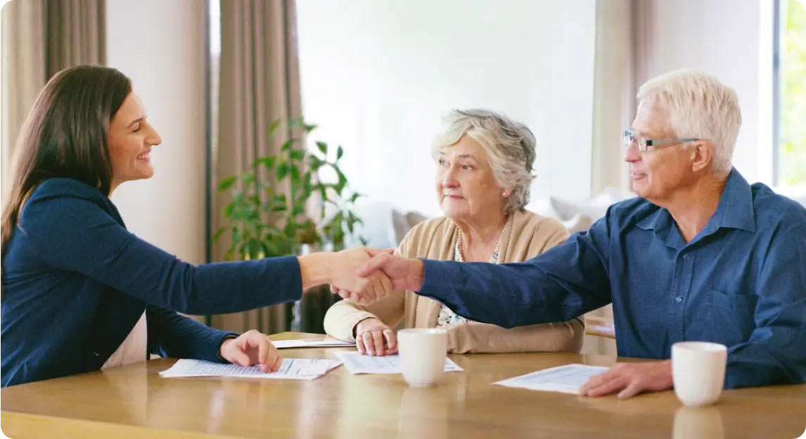 Older couple shaking hands with lawyer