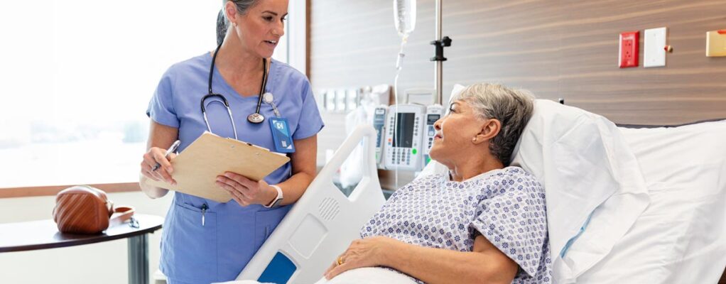 A female patient speaks to her doctor from a hospital bed