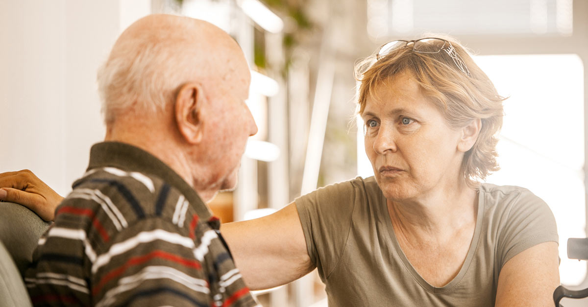 A woman who appears to be around 40-50 is looking intensely at a much older man who may be her father.