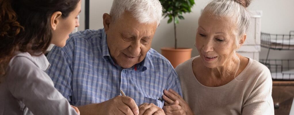 Older man and woman sign legal paperwork