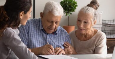 Older man and woman sign legal paperwork